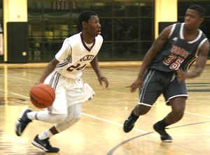 Tucker's Joshua Parker dribbles against Lee County's Otis Reece while running the offense in the Tigers' big win. (Photo by Mark Brock)