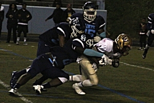 Cedar Grove's Elysee Mbem-Bosse (8) and Adrian Fendell (25) team up to make a big defensive stop at their own eight-yard line. (Photo by Mark Brock)