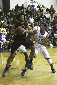 Tucker's Adonis Green (with basketball) goes up against Lakeside's Martin Haggray (45) during the Tigers' 65-40 Region 2-6A win on Tuesday night at Lakeside. (Photo by Mark Brock)