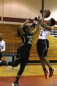 Stone Mountain's Alexis Stephens-Warren (2) puts in the first points of the night against Lithonia's Kayln Greer (10). (Photo by Mark Brock)