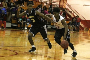 Stone Mountain's Rico Huff (12) drives against Lithonia's Sydarius Stinton (3) during Region 6-4A boys' action on Friday. (Photo by Mark Brock)