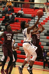 Miller Grove's Colin Young beats a pair of Carver defenders to the basket in Miller Grove's playoff clinching win. (Photo by Mark Brock)