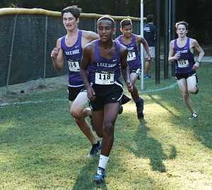 Lakeside's Alex Bachman (far left) passes teammate Mikias Mekonen to win the gold in the boys' JV Championships.  (Photo by Mark Brock)