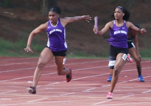 Miller Grove's Tacari Demery (left) took the baton from teammate Chance Barnes and cliched first in the 4x100 meter relay at the DCSD County Championships in March.. The pair hope to lead the Lady Wolverines to a state track championship this weekend. (Photo by Mark Brock)