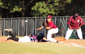 Martin Luther King Jr. baserunner Caleb Chisholm (8) dives back into first safely as Tucker first baseman Kase Supples awaits a throw. (Photo by Mark Brock)