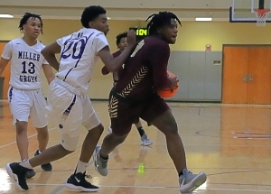 Tucker guard Raylan Barrian (with ball) gets past Miller Grove defenders Tyreik Boyd (13) and Matthew McCullum (20) for a fourth quarter basket in the Tigers 61-59 thriller. (Photo by Mark Brock)