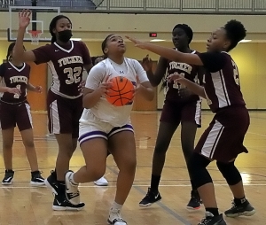 Miller Grove's Jalina Robinson gets in the lane against Tucker defenders Jacinta Hollins (32), Ashoul Yak (11) and Kristan Simmons (21). Robinson keyed a fourth-quarter rally to lead Miller Grove to a 43-35 win. (Photo by Mark Brock)