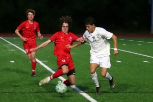 Dunwoody's Nate Lambert (13) battles Discovery's Justin Acosta (10) during first half action of Discovery's 2-0 7-7A boys' win. (Photo by Mark Brock)