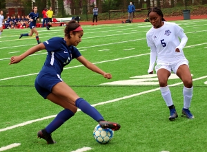 Dunwoody Sarah Holland (left) makes a move on Discovery's Zoi Sinclair (right) during Dunwoody's 7-0 7-7A  victory. Holland had four second half assists to lead the Wildcats in the win. (Photo by Mark Brock)