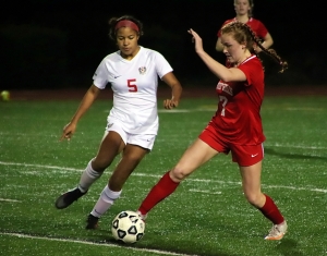Dunwoody's Sarah Holland (5) battles Druid Hills Reese Rathur (7) for the ball during Dunwoody's 10-1 win on Friday night. (Photo by Mark Brock)