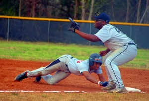 Martin Luther King's Leigh Allen dives safely back to first as Lithonia first baseman Wesley Covert waits for a throw during the Lions 11-4 win at Lithonia. (Photo by Mark Brock