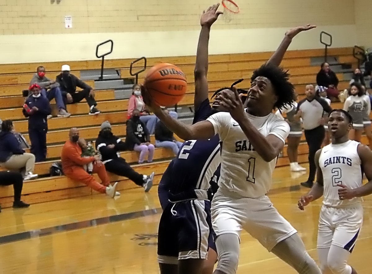 Cedar Grove's Ricky Lee (1) gets past Redan's Alfolabia Caulker (2) for two of his 18 points in Cedar Grove's 57-54 Region 5-3A win on Tuesday. (Photo by Mark Brock)