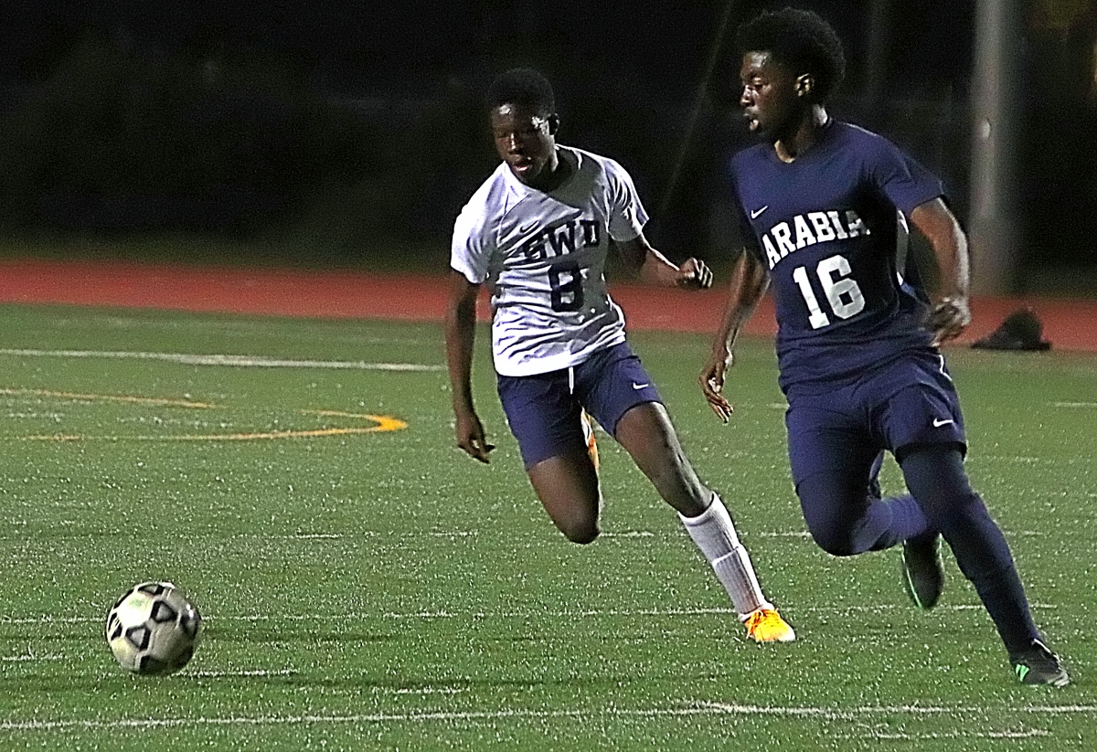 Southwest DeKalb's Ezekial Babara (8) races to the ball against Arabia Mountain's Mulbah Guilavogui (16). Babara had a goal and an assist on the night in the Panthers' 4-1 win. (Photo by Mark Brock)