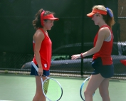 Dunwoody's Mei Stafford (left) and Ginny Duffy (right) discuss strategy during their 6-0, 6-0 win at No. 1 doubles against Camden County's Ryleigh Blount and Hannah Coffman. (Photo by Mark Brock)