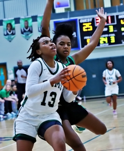 Arabia Mountain's Sierra Burns (13) gets past McIntosh's Maya Nowell for a layup during second half action of Arabia's 65-39 Class 5A girls' first round state playoff win. (Photo by Mark Brock)