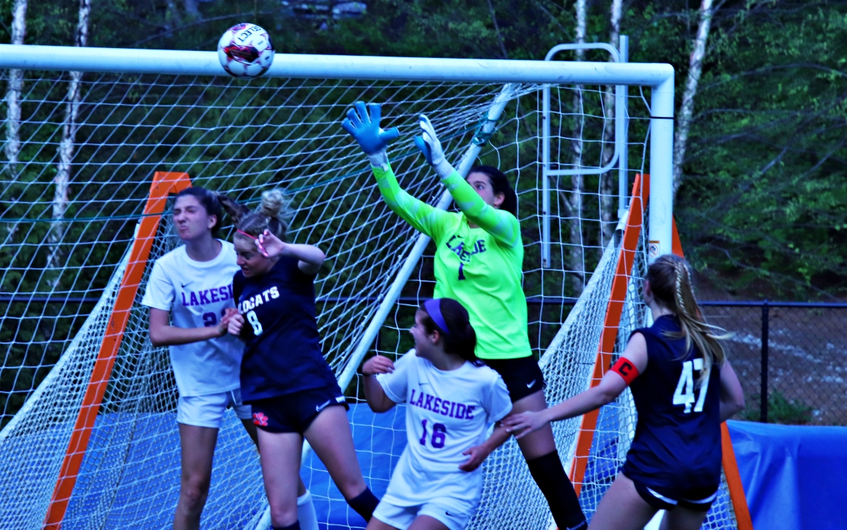 Lakeside's Isabella La Madrid (in green) goes up in a crowd to make a save off a Dunwoody corner kick. She had seven saves as the Lady Vikings knocked off Dunwoody 3-0 to reach the state playoffs. (Photo by Mark Brock)
