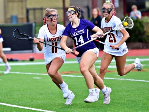 Lakeside's Reagan Flanagan (14) slips past Lassiter defenders Sophie Hortman (11) and Kyla Caimano (21) and heads up field. Flanagan scored two of the Lady Vikings six goals in the 18-6 first round playoff loss to Lassiter. (Photo by Mark Brock)