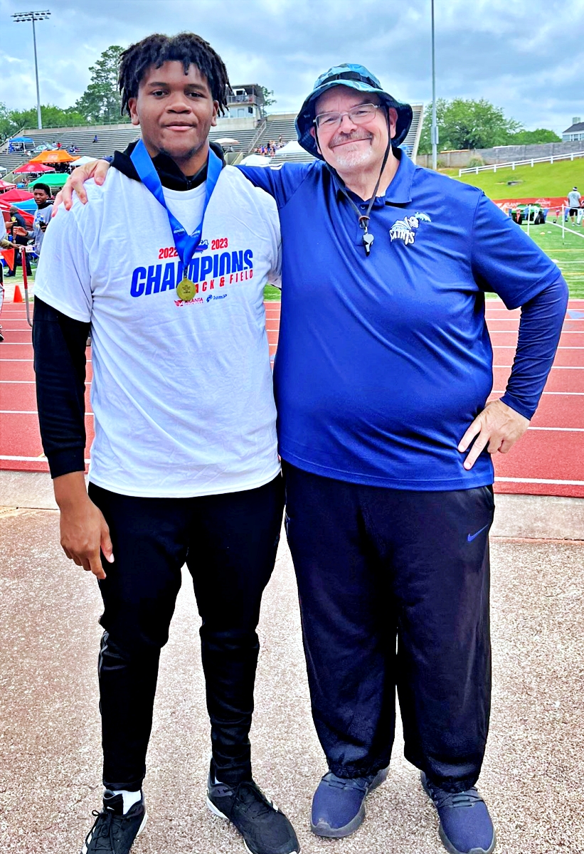 Cedar Grove senior Solomon Hall (left) and Coach Darren Spence celebrate Hall's gold medal in the shot put at the Class 3A state competition.