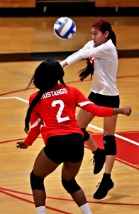 McNair's Ashley Gomez (in white) returns a ball as teammate Kei'Asia Clayton (2) waits to hellp. (Photo by Mark Brock)