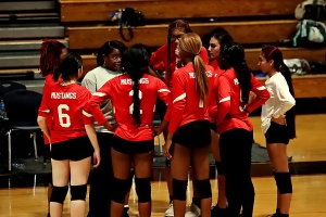 McNair volleyball coach Gwen Edwards (in middle) goes over some strategy with the Lady Mustangs during a timeout. (Photo by Mark Brock)