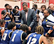 Southwest DeKalb boys' basketball coach Eugene Brown (standing center) gives directions to his team during a timeout. Brown now has over 300 wins in DeKalb and over 400 in 25 seasons of coaching. (Courtesy photo)
