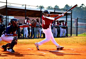 Martin Luther King's Calvin Carter delivers a run-scoring hit in the first inning against Arabia Mountain. Rams catcher Nick Knotts was behind the plate. Carter had three RBI in the win. (Photo by Mark Brock)