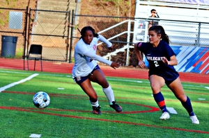 Dunwoody's Ella Ryan (right) gets past South Cobb defender Trinity McDaniel during an 8-0 first half by the Lady Wildcats. Ryan scored on goal and assisted on two more in the 9-0 victory. (Photo by Mark Brock)