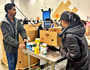Southwest DeKalb tennis players, sophomore Tristan Rudolph (left) and Madison Venable (right), prepare a care box at the Atlanta Community Food Bank. 