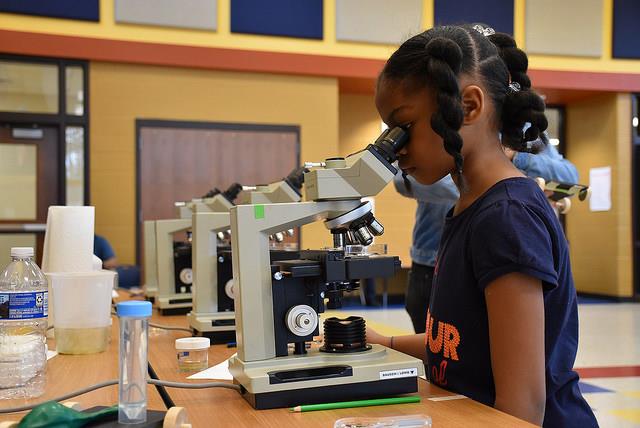 female student looking into a microscope