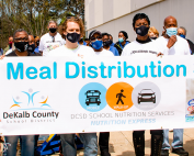 people walking with meal distribution banner